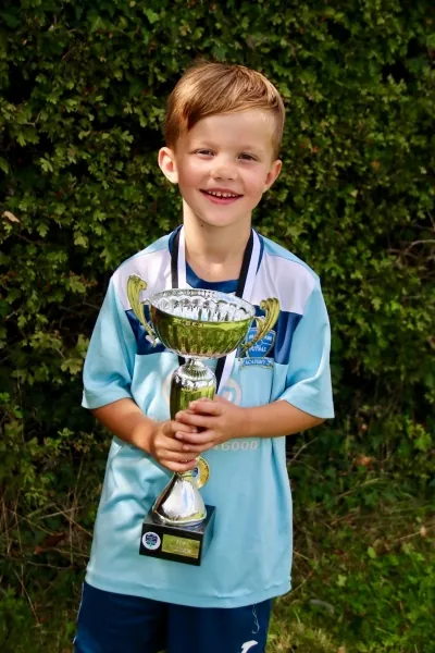 A young Braintree player holding a trophy outdoors