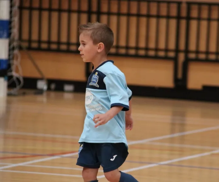 A young Braintree player moving across the court in a light-blue kit