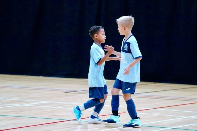 Two young Braintree teammates greeting each other on the court