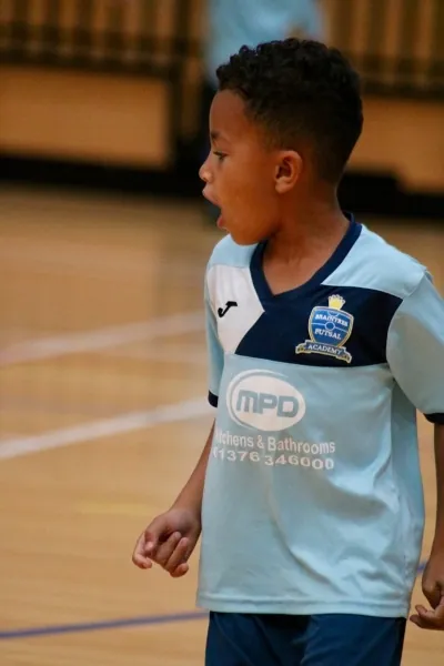 A young Braintree academy player in a light-blue kit watching the game