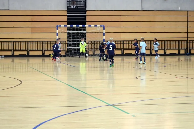 Young futsal players contesting the ball near the goal at the Copper Box