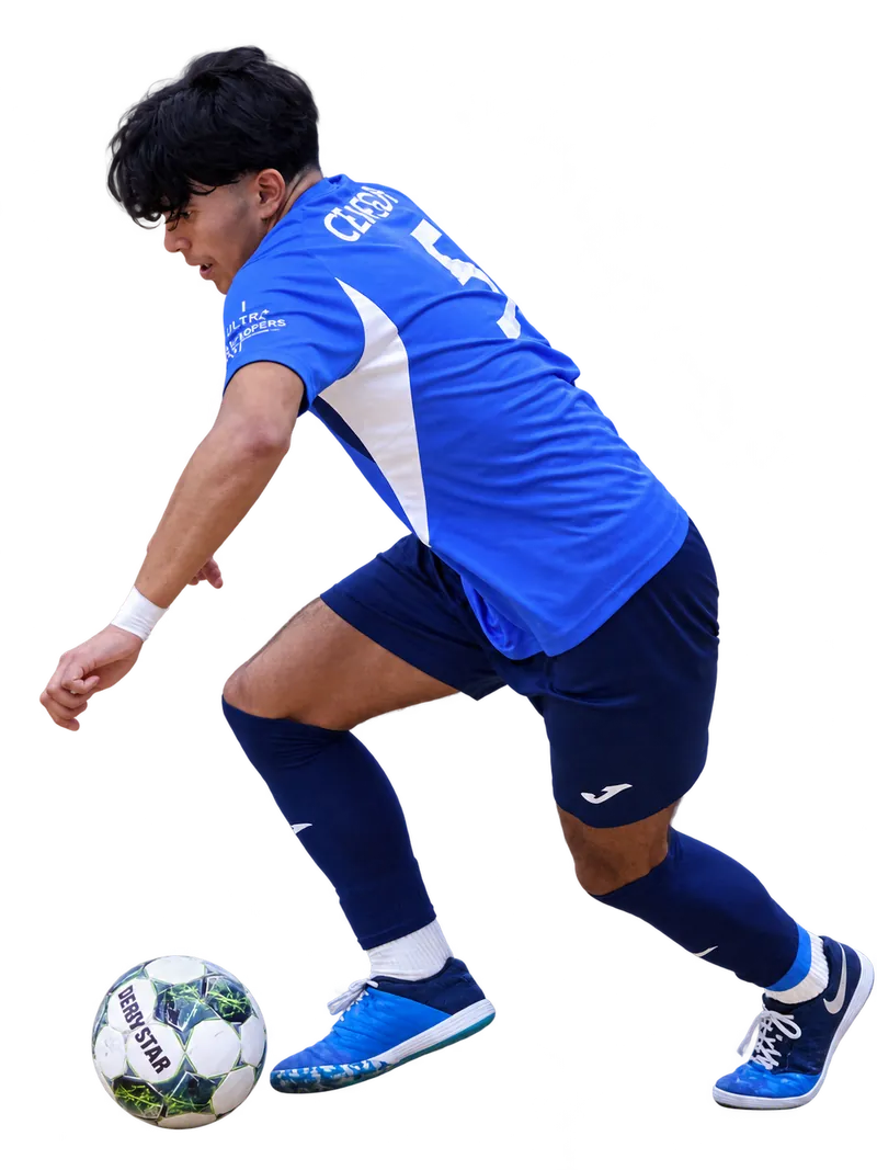 Braintree Futsal player in a blue shirt dribbling a green and white ball